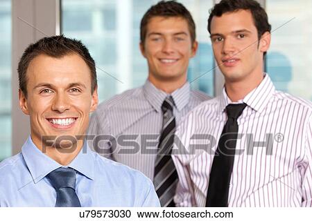 Three businessmen smiling at office, portrait View Large Photo Image Stock Image - Three businessmen smiling at office, portrait. Fotosearch