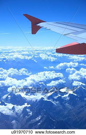 View from the plane over snowy mountains View Large Photo Image Stock Image - View from the plane over snowy mountains. Fotosearch