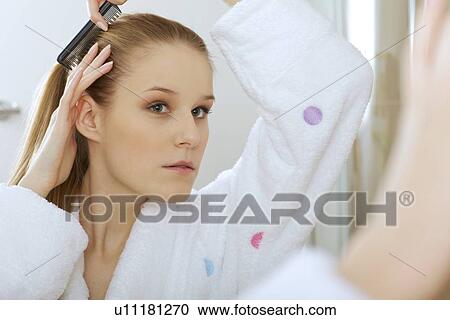 Stock Image - Woman brushing hair. Fotosearch