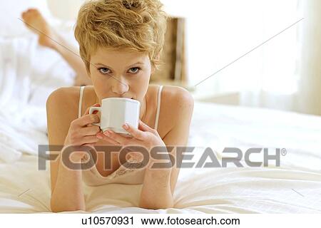 Woman drinking coffee in bed View Large Photo Image Stock Image - Woman drinking coffee in bed. Fotosearch