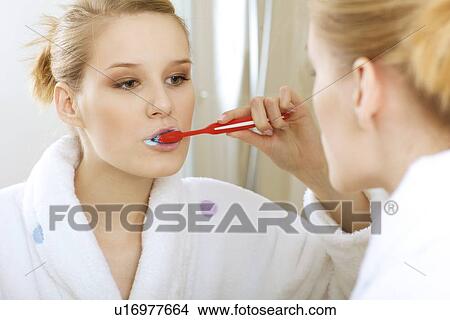 Woman in bathroom brushing teeth View Large Photo Image Picture - Woman in bathroom brushing teeth. Fotosearch