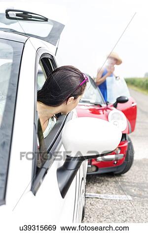 Woman looking at female crashing car on road View Large Photo Image Stock Photo - Woman looking at female crashing car on road. Fotosearch