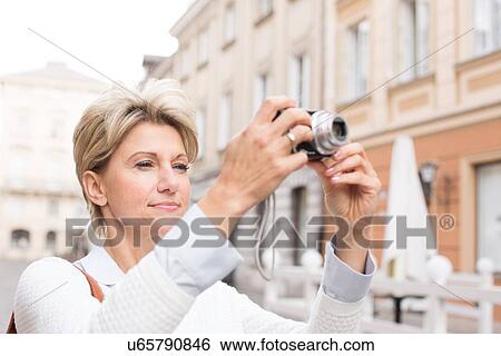 Woman photographing through digital camera in city View Large Photo Image Stock Photograph - Woman photographing through digital camera in city. Fotosearch