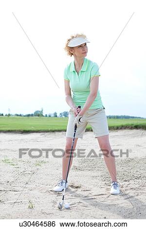 Woman playing golf at course against clear sky View Large Photo Image Stock Photograph - Woman playing golf at course against clear sky. Fotosearch