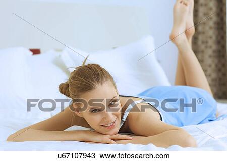 Woman relaxing in bed View Large Photo Image Stock Image - Woman relaxing in bed. Fotosearch