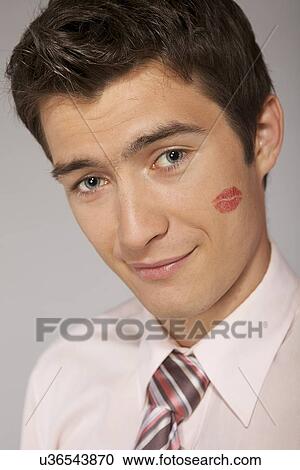 Young caucasian businessman with lipstick kiss mark on his cheek View Large Photo Image Stock Image - Young caucasian businessman with lipstick kiss mark on his cheek. Fotosearch