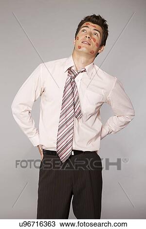 Young caucasian businessman with lipstick kiss mark on his cheek View Large Photo Image Stock Image - Young caucasian businessman with lipstick kiss mark on his cheek. Fotosearch
