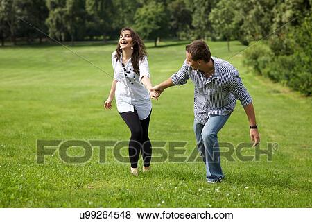 Stock Photo - Young couple enjoying in park. Fotosearch