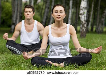 Stock Image - Young couple exercising in park. Fotosearch