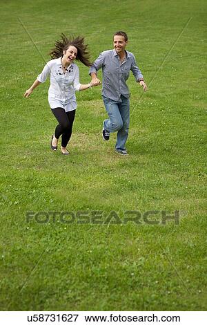 Stock Photo - Young couple running in park. Fotosearch