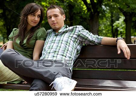 Young couple sitting on bench View Large Photo Image Stock Photo - Young couple sitting on bench. Fotosearch
