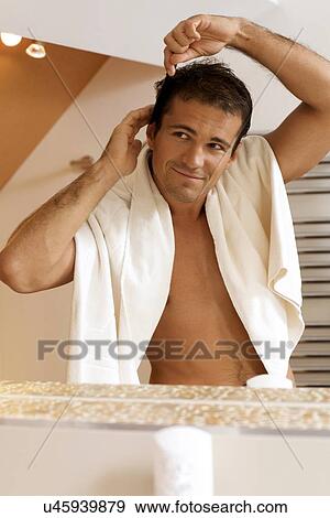 Young man combing his hair View Large Photo Image Stock Photo - Young man combing his hair. Fotosearch