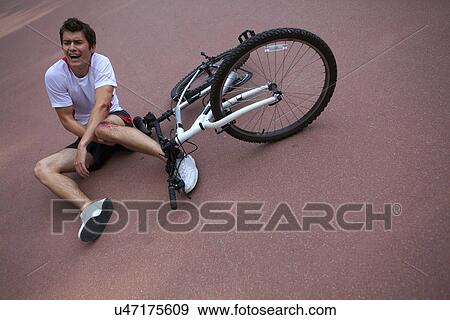 Stock Photo - Young man injured during riding a bike. Fotosearch