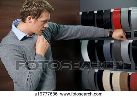 Stock Photograph - Young man looking at color swatch. Fotosearch