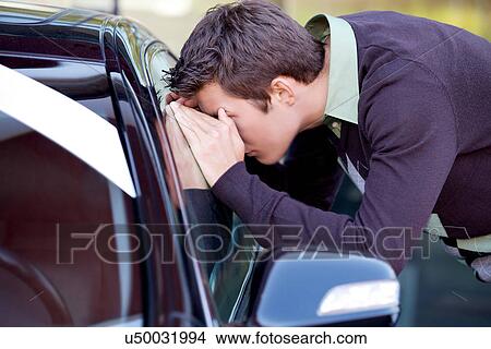 Young man looking at new car View Large Photo Image Picture - Young man looking at new car. Fotosearch