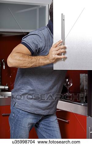 Young man looking in refrigerator View Large Photo Image Picture - Young man looking in refrigerator. Fotosearch