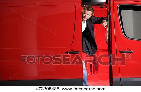 Young man looking through van door View Large Photo Image Stock Photo - Young man looking through van door. Fotosearch