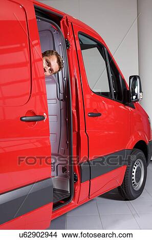 Young man peeking through van door View Large Photo Image Picture - Young man peeking through van door. Fotosearch