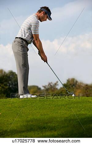Stock Photo - Young man playing golf. Fotosearch