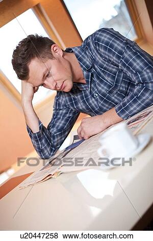 Stock Photo - Young man reading newspaper. Fotosearch