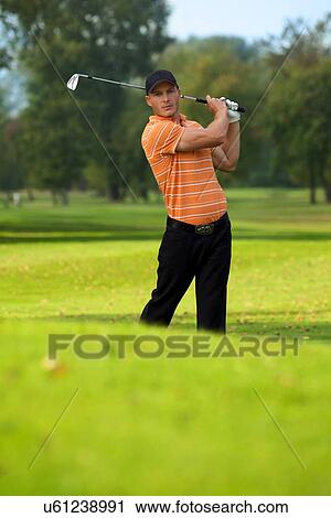 Young man swinging golf club View Large Photo Image Stock Image - Young man swinging golf club. Fotosearch