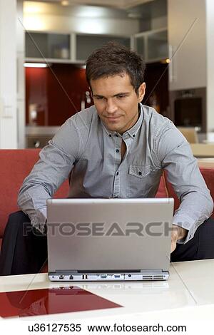 Stock Photography - Young man using laptop. Fotosearch