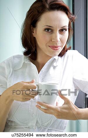 Picture - Young woman drinking coffee in the morning. Fotosearch