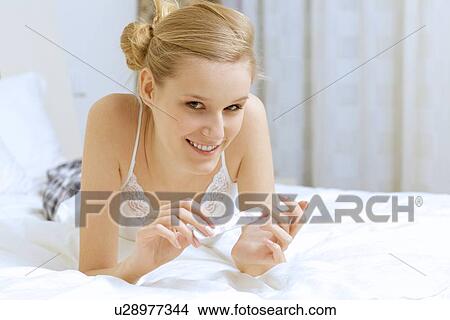 Picture - Young woman filing her nails. Fotosearch