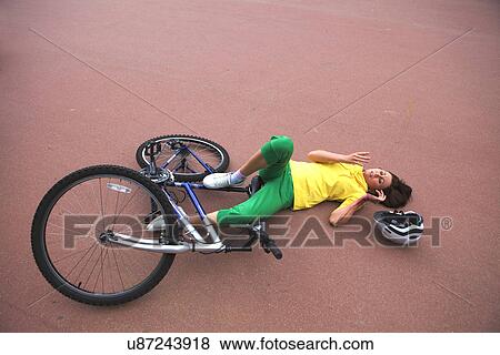 Stock Photo - Young woman injured during riding a bike. Fotosearch