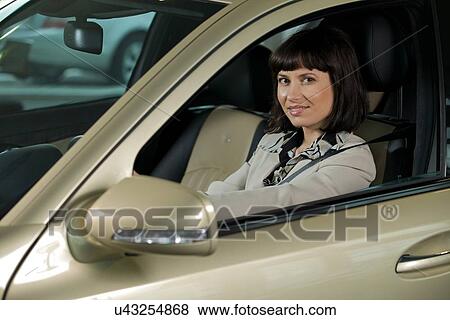 Stock Photo - Young woman looking at new car. Fotosearch