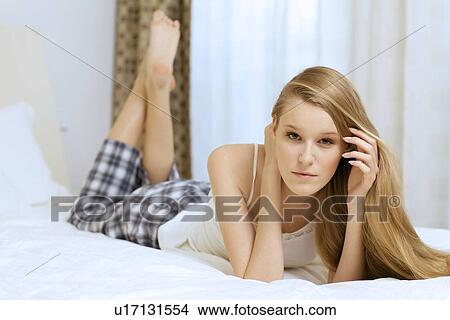 Picture - young woman lying in bed. Fotosearch