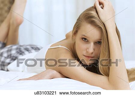 Stock Image - young woman lying in bed. Fotosearch