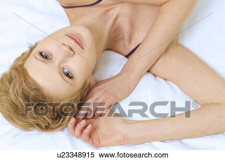 Stock Photography - young woman lying in bed. Fotosearch