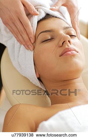 Stock Photo - Young woman receiving energy therapy, eyes closed. Fotosearch