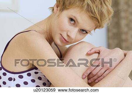 Stock Photo - young woman sitting in bed. Fotosearch