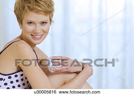 Stock Photograph - young woman sitting in bed. Fotosearch