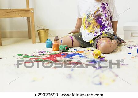 Stock Image - Boy (2-3) painting on carpet. Fotosearch
