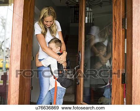 Boy (6-7) hugging mother before leaving for school View Large Photo Image Stock Photo - Boy (6-7) hugging mother before leaving for school. Fotosearch