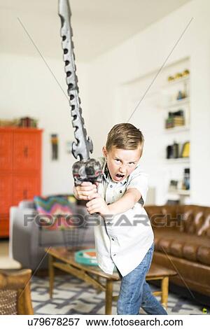 Stock Photo - Boy (6-7) playing with sword. Fotosearch