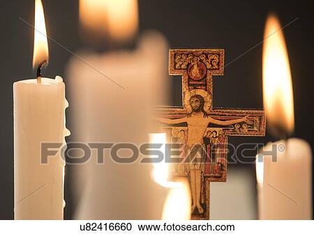 Stock Image - Burning candles and cross. Fotosearch