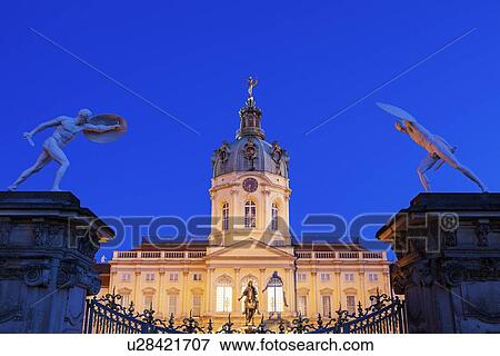 Stock Photo - Charlottenburg Palace facade and entrance statues at night. Fotosearch