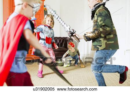 Stock Photography - Children (2-3, 4-5, 6-7) wearing superhero costumes playing at home. Fotosearch