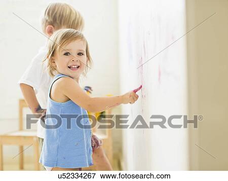 Children (2-3) painting on wall View Large Photo Image Stock Photo - Children (2-3) painting on wall. Fotosearch