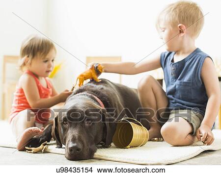 Children (2-3) playing with dog View Large Photo Image Picture - Children (2-3) playing with dog. Fotosearch