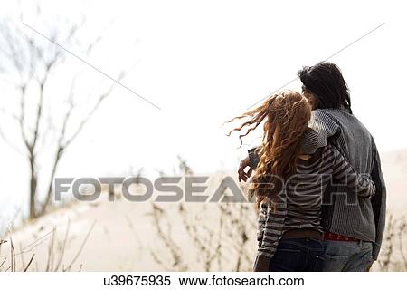 Stock Photography - Couple standing on beach. Fotosearch