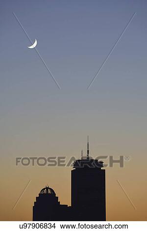 Picture - Crescent moon above office buildings. Fotosearch