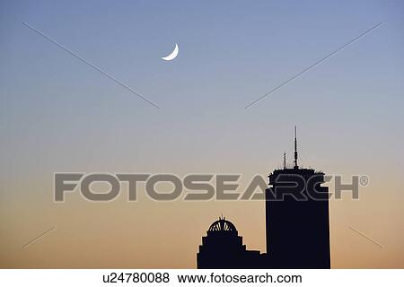 Stock Photo - Crescent moon above office buildings. Fotosearch