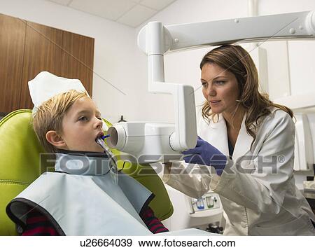 Dentist and patient (8-9) in dentist's office View Large Photo Image Stock Photo - Dentist and patient (8-9) in dentist's office. Fotosearch