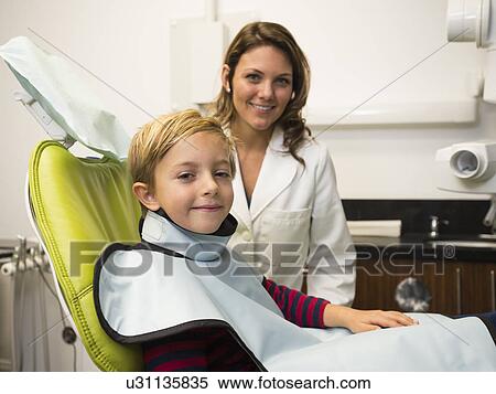 Stock Photography - Dentist and patient (8-9) in dentist's office. Fotosearch