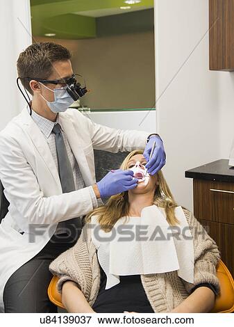 Dentist and patient in dentist's office View Large Photo Image Stock Photo - Dentist and patient in dentist's office. Fotosearch